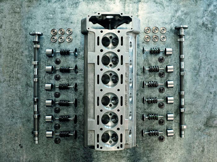 La clave del motor XK: la culata de doble árbol aparecida en 1948, que situó a Jaguar en cabeza del mercado al ofrecer dicha tecnología a unos precios bastante asequibles (berlina Mk.VII y deportivo XK-120). En principio el ángulo entre válvulas era de 70º; pero la de alto rendimiento (o sea ésta) lo abrió hasta 80º para poner válvulas más grandes. Quizás el tamaño de la foto no permita apreciar el doble muelle interior de hélice invertida, con el antivibrador elástico interpuesto entre ambos.