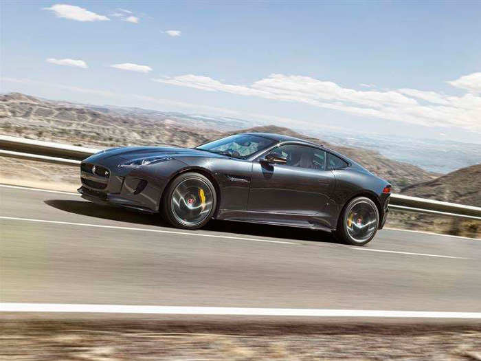 El Jaguar F-Type a/m’16 en versión Coupé R S/C en plena subida por una carretera que –como en las demás fotos- tiene todo el aspecto de ser española, por paisaje, asfalto, pintura, arcenes y guarda-railes.