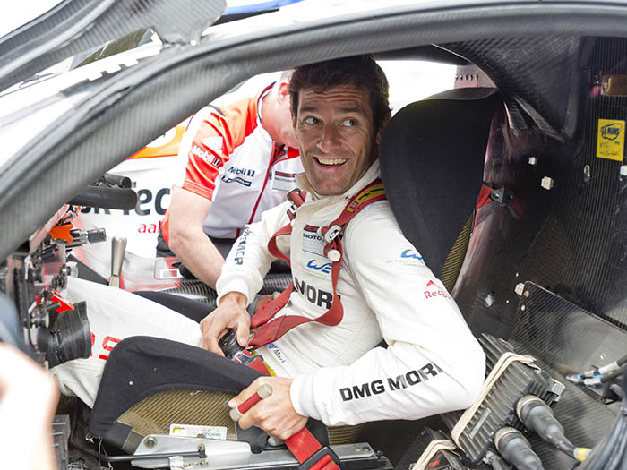 En el Goodwood Festival of Speed de 1914 las cosas cambian; Mark Webber se embute en el “bucket seat” de un semi-clásico: el 911 GT-1 (cosecha 1998, delatado por la pegatina amarilla de verificación) que Alan McNish llevó a la victoria en Le Mans (copilotado por Aiello y Ortelli), y se abrocha (como nos gusta a JotaEme y a mí) un arnés que le dejará pegado al asiento. Y luego encastrará el volante (abierto por arriba) que reposa en lo alto del salpicadero.