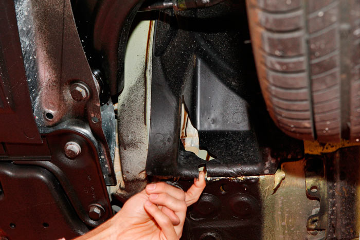 Renault Clio 2013. La pieza que cubre el paso de la rueda delantera izquierda está estropeada